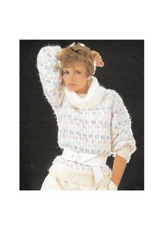 a woman in white sweater and shorts with her hands on her head, posing for the camera