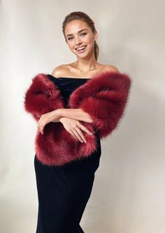 a woman wearing a black dress and red fur stole