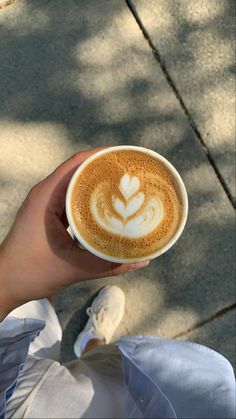 a person holding a cup of coffee in their hand