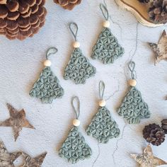 crocheted ornaments are arranged on a table next to pine cones and other decorations