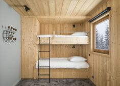 a bunk bed in a room with wood paneling