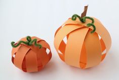 two orange paper pumpkins sitting next to each other