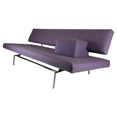 a purple couch sitting on top of a metal frame with an arm rest in front of it