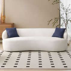 a white couch sitting on top of a black and white rug