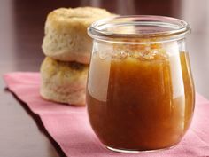 a glass jar filled with food sitting on top of a pink napkin next to a piece of bread