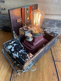 an old fashioned lamp sitting on top of a wooden table next to a wallet and other items