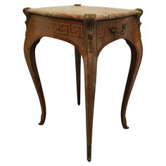 an antique wooden table with carvings on the top and bottom, sitting against a white background