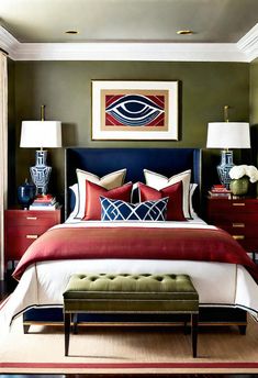 a bedroom with green walls, red and white bedding, two lamps on either side of the bed