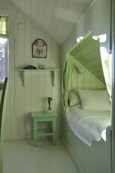 there is a small green bed in the corner of this room with white walls and flooring