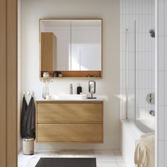 a bathroom with a sink, mirror and bathtub