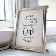 a white framed sign sitting on top of a window sill