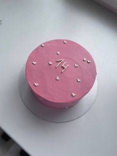 a pink cake sitting on top of a white table