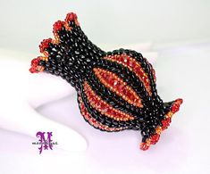 a black and red beaded bracelet on a white mannequin headdress