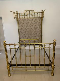 a gold metal bed frame with an upholstered headboard