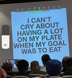 people sitting in front of a large screen with words on it