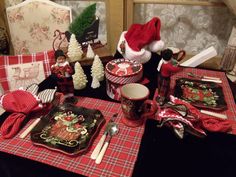 the table is set for christmas dinner with red and white plaid napkins on it