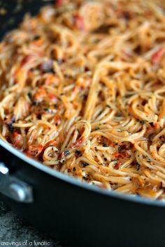 a pan filled with pasta and sauce on top of a table