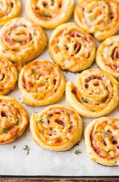 several mini pizzas with cheese and ham on them