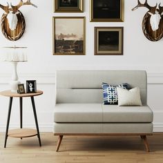 a living room filled with furniture and framed pictures on the wall above it's couch