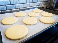 six uncooked cookies on a baking sheet in an oven