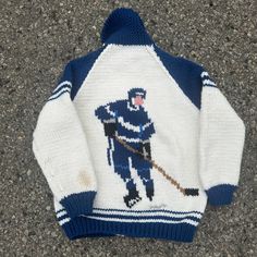 an old sweater with a hockey player on it is laying on the ground and has a stick in its hand