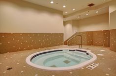 an indoor jacuzzi tub in the middle of a room with tiled walls and flooring