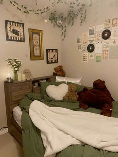 two teddy bears sitting on top of a bed in a room with pictures and decorations