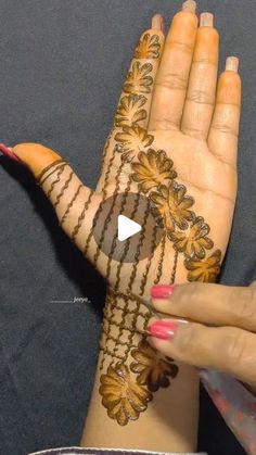 a woman's hand with henna tattoos on it