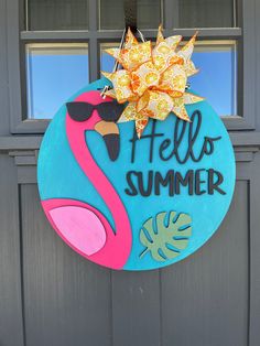 a blue door with a pink flamingo and hello summer sign on it's side