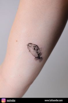 a small fish tattoo on the arm