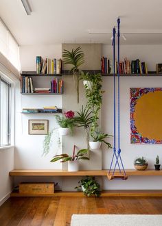 a living room filled with lots of plants and books