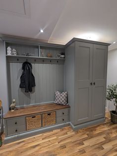 a room with some gray cabinets and drawers on the wall next to a wooden floor