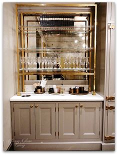 a bar with lots of glasses on top of it in a room filled with furniture