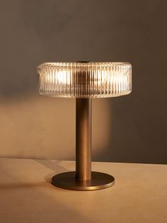 a lamp that is sitting on top of a table next to a wall and floor