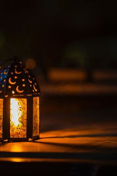 a lit lantern sitting on the ground at night