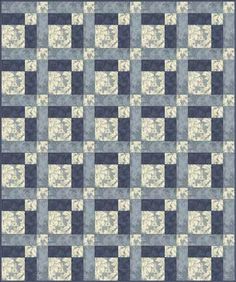 a blue and white quilt with squares on the front, in shades of gray and beige