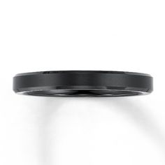 a black wedding band is shown against a white background