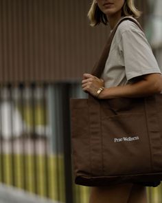 Tegan with our Chocolate Tote Bag, for moments on the go. Featuring an easy-access front pocket, which is designed to hold your water bottle or other essentials.