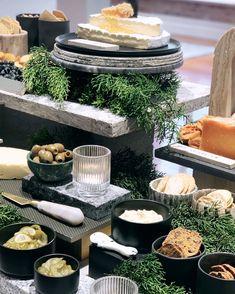 a table topped with lots of different types of cheeses and other food items next to each other