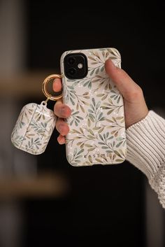 a person holding up a phone case with two rings on it