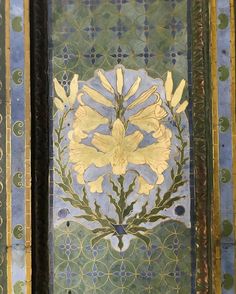 an ornate painting with yellow flowers on blue and green tiles