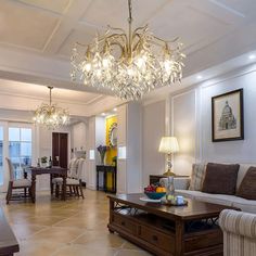 a living room filled with furniture and a chandelier hanging over the top of it