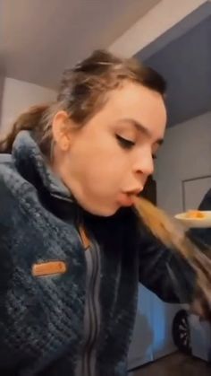 a woman eating food from a white plate