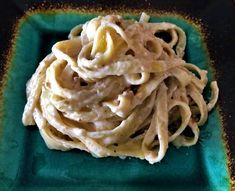 a green plate topped with pasta and sauce