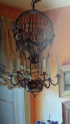 a chandelier hanging from the ceiling in a room with paintings on the walls