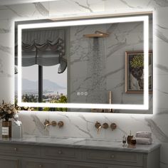 a bathroom with marble counter tops and a large mirror over the sink that has lights on it