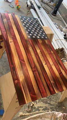 an american flag made out of wood sitting on top of a piece of plywood