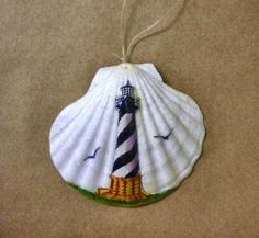 a seashell ornament with a lighthouse on it