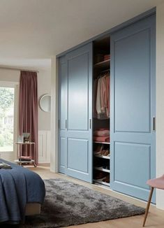 a bedroom with blue closets and pink curtains