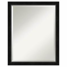 a black framed mirror on a white wall with an empty space for the image to be taken